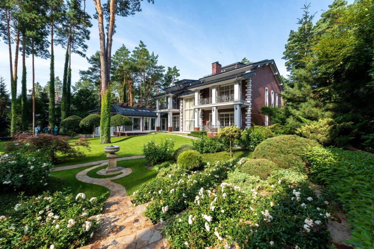 Elegant brick home surrounded by lush landscaping and gardens representing Macon, GA real estate