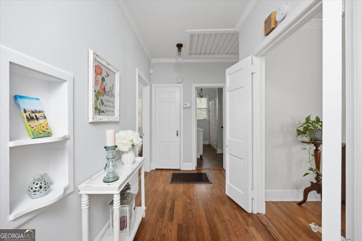 Interior hallway at 3850 The Prado in Macon GA featuring hardwood floors, classic trim details, natural light, and charming traditional design elements