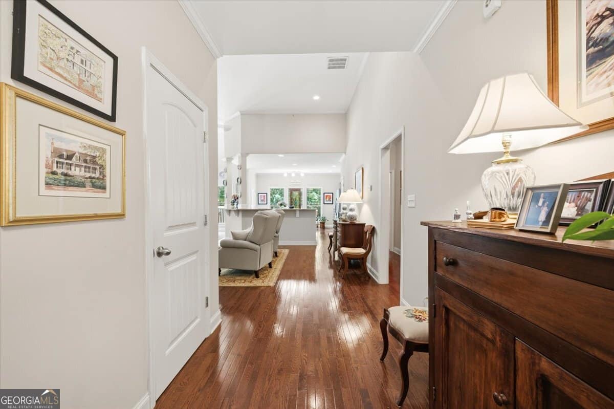 Interior entry hallway at 103 N Knotty Court in Forsyth GA featuring hardwood floors, elegant lighting, and open view into spacious living area