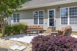 Patio and landscaped backyard sitting area at 411 Dixieland Drive in Byron GA offering private outdoor living space in Peach County