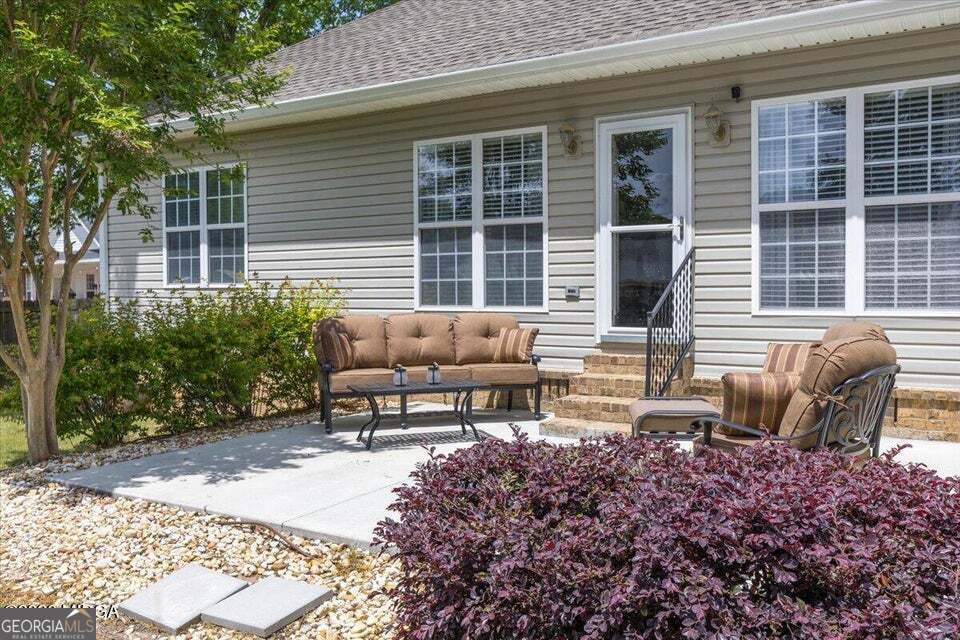 Patio and landscaped backyard sitting area at 411 Dixieland Drive in Byron GA offering private outdoor living space in Peach County