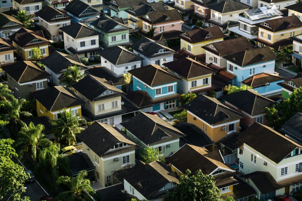 Aerial view of a suburban residential neighborhood with single-family homes, showcasing a thriving real estate community and housing market.