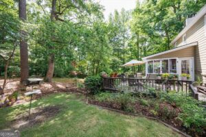 Backyard deck and sunroom overlooking mature trees and garden beds at 1301 Craddock Way in Macon GA.